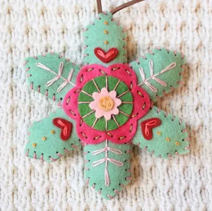 Detailed macro view of a handmade embroidered felt snowflake Christmas decoration
