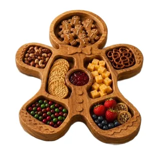 Gingerbread man shaped wooden divided tray filled with Christmas snacks and fruits