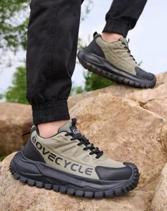 Primer plano de zapatos de seguridad verdes con puntera de acero en terreno rocoso