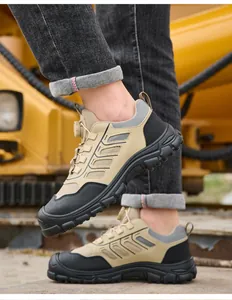 Detail view of khaki safety shoes with quick-lacing knob system in industrial setting.