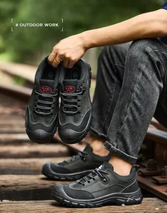 Detail view of durable black safety work shoes for outdoors on a railway track.