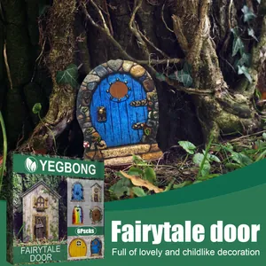 Close-up of a blue miniature fairytale garden door decoration against a tree trunk