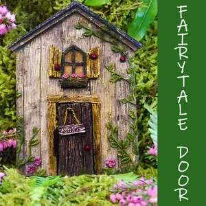 Close-up of a rustic miniature fairy door with pink floral accents on green moss