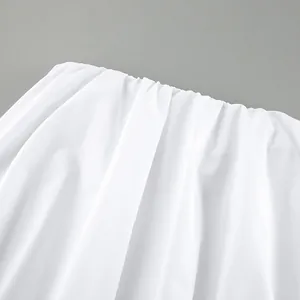 Primo piano del tessuto a pieghe bianco di un top a fascia stile vacanza.