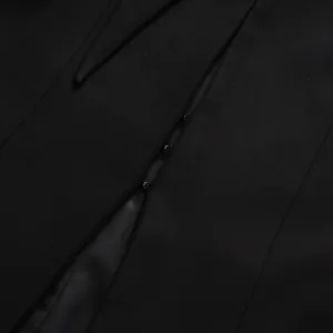 Detailed macro view of a hidden hook-and-eye closure on a premium black tailored blazer.