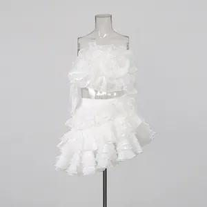 Detail view of a white floral patchwork tube top and ruffled tiered skirt set on a stand