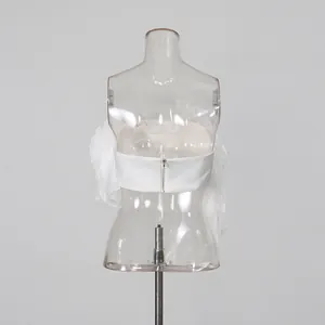 Detailed back view of white ruffled strapless top featuring central zipper closure.