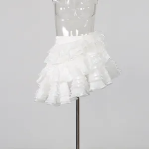 Detail showing the elegant white tiered ruffled mini skirt with layered floral accents