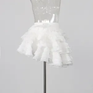 Detailed close-up view of a white multi-layered ruffle mini skirt on a mannequin