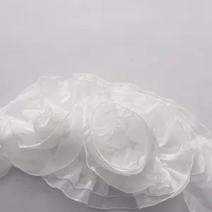 Close-up detail of white ruffled floral chiffon fabric on a summer tube top