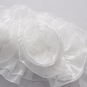Macro view of delicate white layered ruffles forming a floral design detail