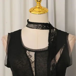 Primo piano di canotta in pizzo nero con dettaglio choker e nastro alla moda.