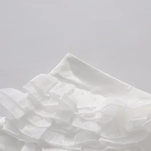 Detailed view of elegant white tiered ruffle layers on a summer two-piece outfit