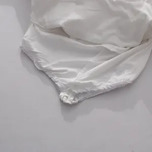 Detail of elasticated hem on white ruffled skirt showing fine stitching and fabric