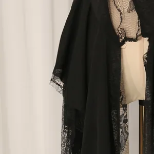 Dettaglio ravvicinato del pizzo nero su un leggero gilet estivo dal design chic