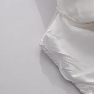 Macro detail showing high-quality white fabric stitching on ruffled summer set