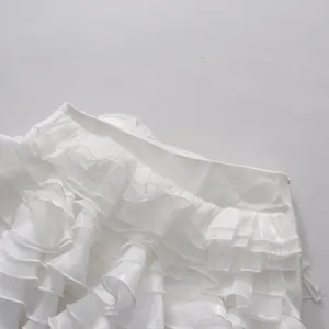 Close-up detail of white layered organza ruffles on a summer two-piece fashion set
