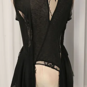 Dettaglio di un top chic in pizzo nero con un accento di sciarpa fluida ed elegante