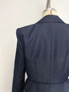 Detailed macro view of navy blue denim jacket showing premium tailored stitching