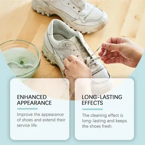 Close-up of hands cleaning dirty white sneakers with foam cleaner on wooden table