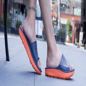 Detail view of lightweight navy and orange dual-tone slide sandals worn outdoors.