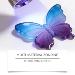 Primer plano de una mariposa de resina en degradado azul y violeta curada con luz UV