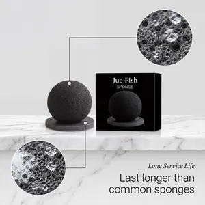 Close-up detail of Jue Fish black spherical cleaning sponge showing its durable porous texture
