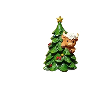 Feestelijk kerstornament van hars met een schattige hooglandkoe die uit de kerstboom kijkt