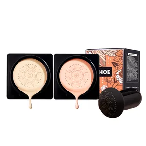 Detalle de dos tonos de base air cushion con aplicador de esponja de hongo y caja de producto