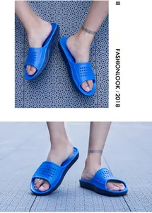 Close-up detail of blue non-slip slides with breathable perforated upper design.