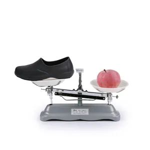 Zapato de chef negro ligero y antideslizante equilibrado con una manzana en una balanza
