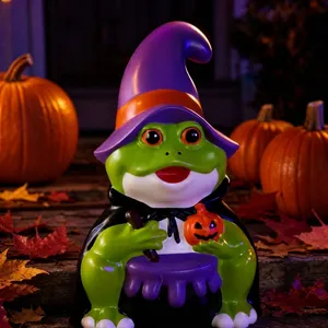 Detalle de primer plano de una figura de rana bruja de Halloween entre calabazas y hojas secas