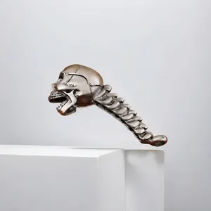 Detailansicht eines Vintage-Bronze-Totenkopf-Flaschenöffners mit Wirbelsäulengriff