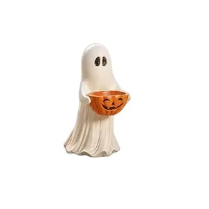 Detailansicht einer weißen Gespensterstatue mit einer orangefarbenen Kürbisschale für Halloween.