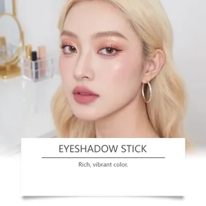 Gros plan professionnel d'un maquillage des yeux or rose étincelant avec bâton d'ombre à paupières