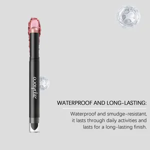Gros plan sur le bâton d'ombre à paupières rose avec sa texture crémeuse et son pinceau