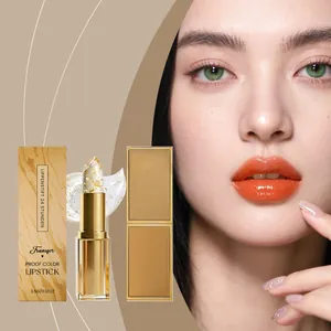 Primer plano de lápiz labial con pan de oro y efecto hidratante naranja natural en modelo