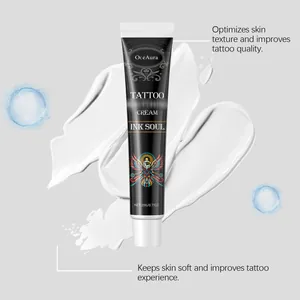 Close-up of OceAura tattoo cream tube against white moisturizing cream texture background