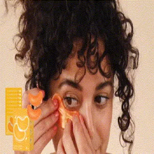 Femme appliquant des masques gelée au curcuma et vitamines pour hydrater le contour des yeux.