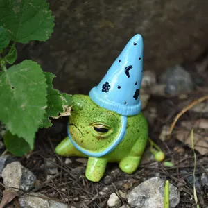 Primer plano de una figura de rana verde con un sombrero de mago azul para decorar jardín