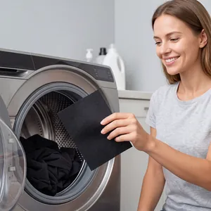 Close-up detail of a black laundry color catcher sheet used for washing dark clothes.