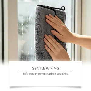 Détail d'un chiffon de nettoyage en microfibre gris doux essuyant une fenêtre en verre