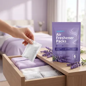 Hand placing a lavender air freshener sachet into a clothes drawer for lasting freshness.