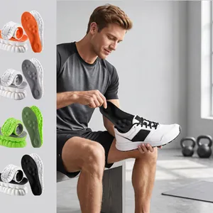 Man inserting breathable cushioned insoles into white sports shoe in gym setting.