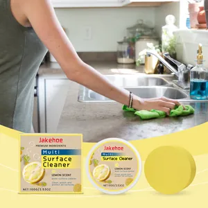 Detail showing Jakehoe multi-surface cleaner packaging, yellow sponge, and kitchen cleaning scene.
