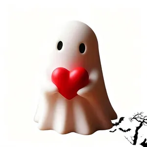 Gros plan d'une figurine de fantôme d'Halloween blanc tenant un grand cœur rouge