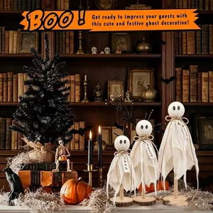 Trois jolies poupées fantômes en lin sur socles en bois dans une scène d'Halloween.