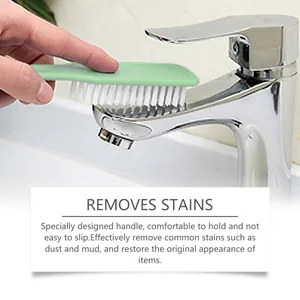 Close-up of a green multi-purpose cleaning brush removing stains from a chrome faucet