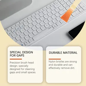 Detail view of an orange gap cleaning brush with nylon bristles cleaning a keyboard