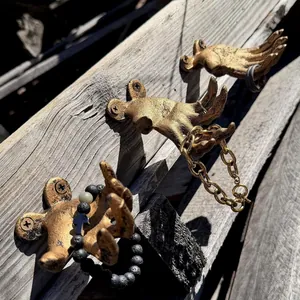 Detailed view of vintage gold hand-shaped wall hooks holding various jewelry pieces